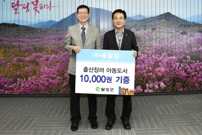 백광균 이사(왼쪽)는 아동도서 1만권을 김문오 군수에 기증했다.