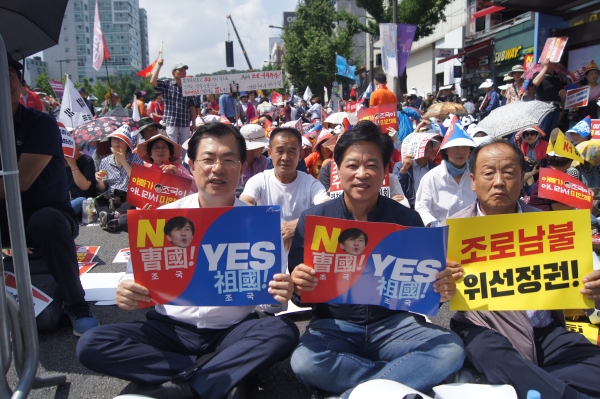 자유한국당 이만희 국회의원(앞줄 왼편)은 31일 서울 장외집회에서 지역구 당원들과 조국 법무장관 후보자 사퇴를 촉구하는 피켓을 들고있다.
