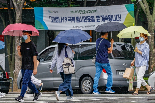 장마가 시작된 24일 오후 비가 내리는 가운데 대구 수성구 한 횡단보도에서 우산을 쓴 시민들이 발걸음을 재촉하고 있다. 전영호기자 riki17@idaegu.co.kr