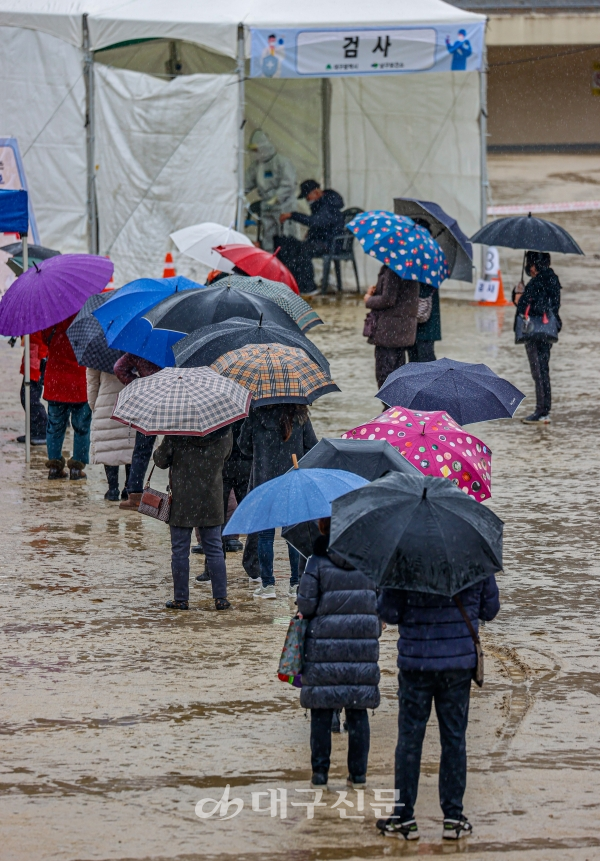 비가 내린 26일 오후 대구 달서구 두류야구장 임시선별검사소에서 우산을 쓴 시민들이 코로나19 검사를 받기위해 순서를 기다리고 있다. 전영호기자 riki17@idaegu.co.kr