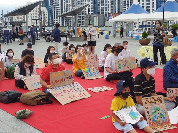 24일 오후 대구기후위기비상행동이 개최한 글로벌 기후파업 동참 집회에 참여한 시민들이 피켓을 들고 앉아 있다. 정은빈기자